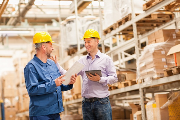 twee mannen met helm aan het werk in opslagplaats